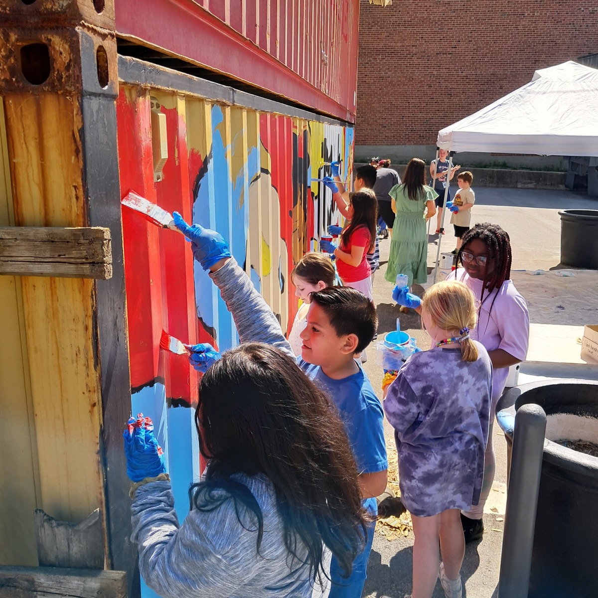 Students from Luff Elementary painting a student deigned mural at Englewood Arts