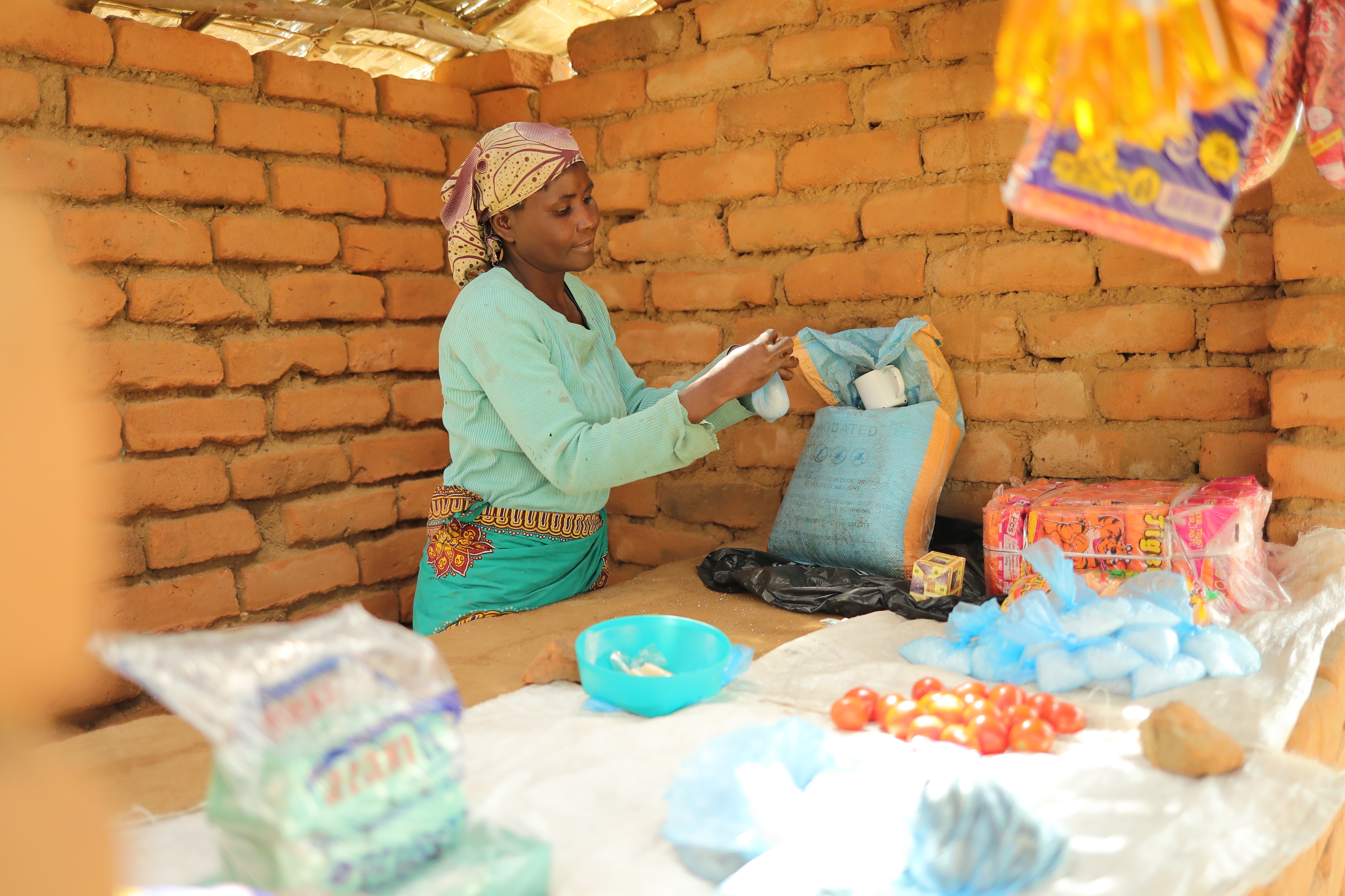 Eliza, a participant in the program, in her grocery stand outside her home