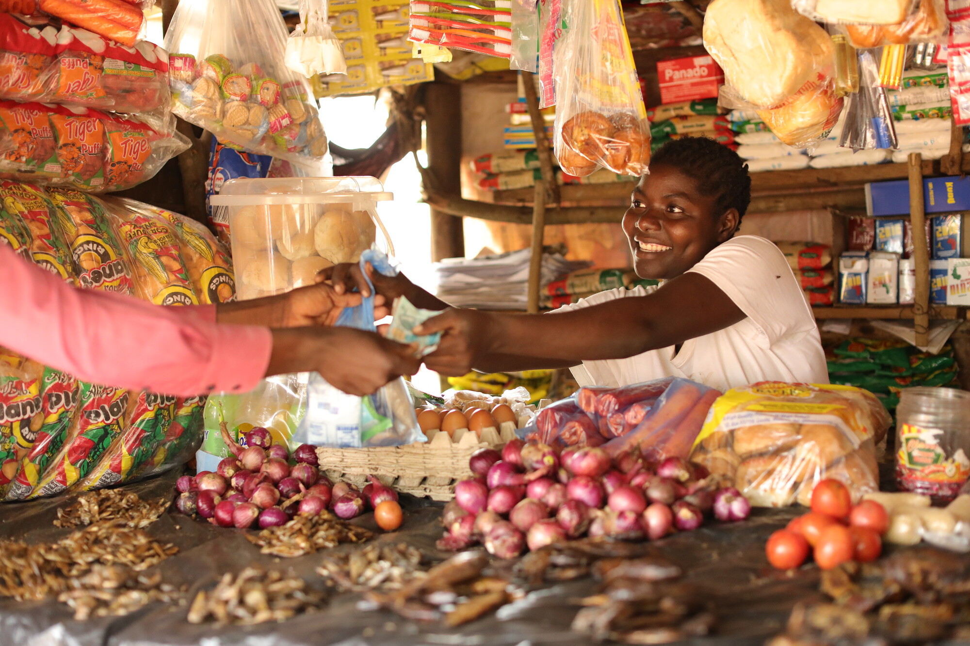 Alinafe, making a transaction at her grocery stand business