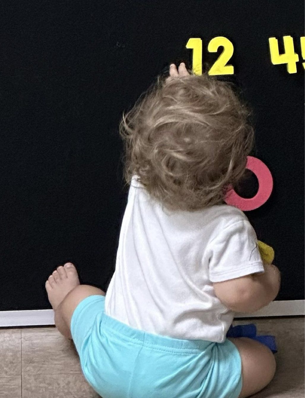 Little one playing with our letter and number board