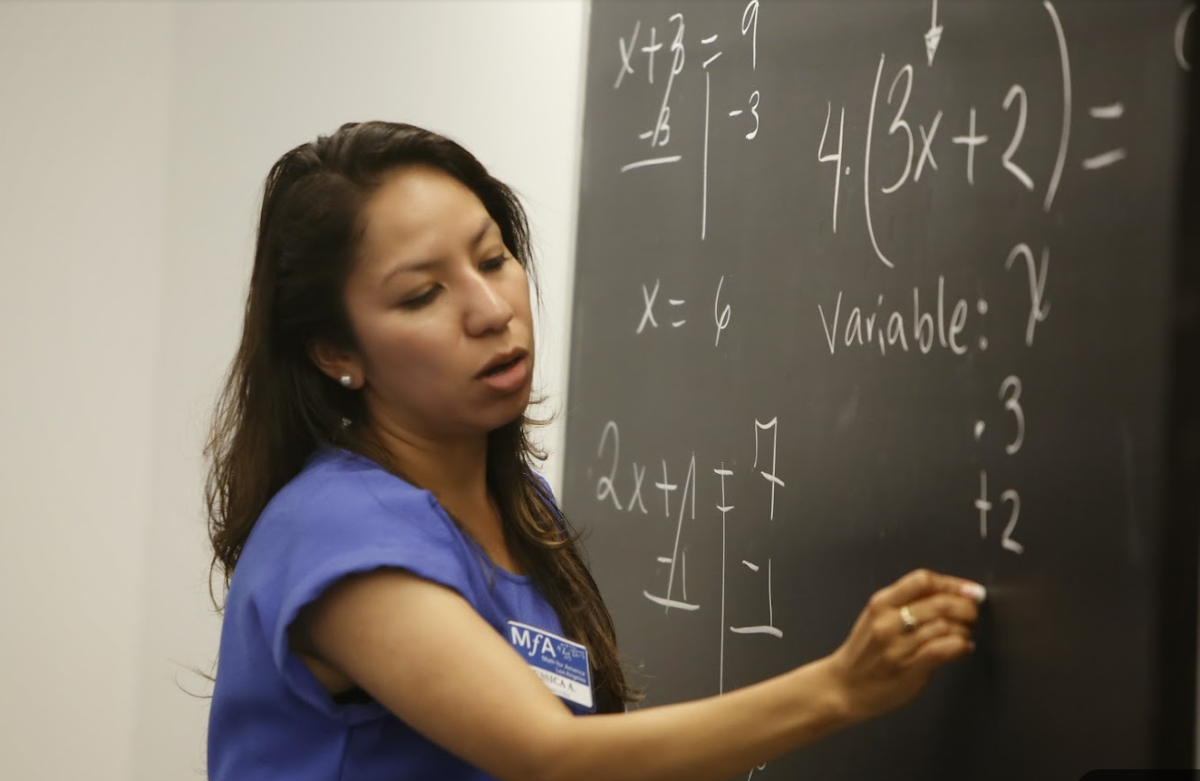 Teacher teaching math at black board