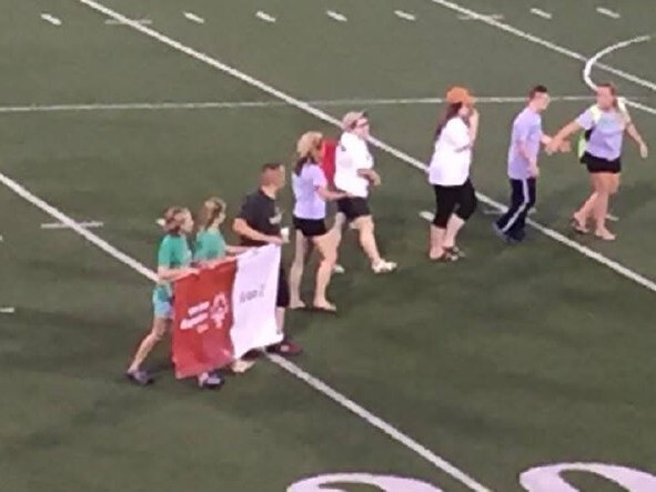 Tess and other athletes carrying the WDSRA banner at state