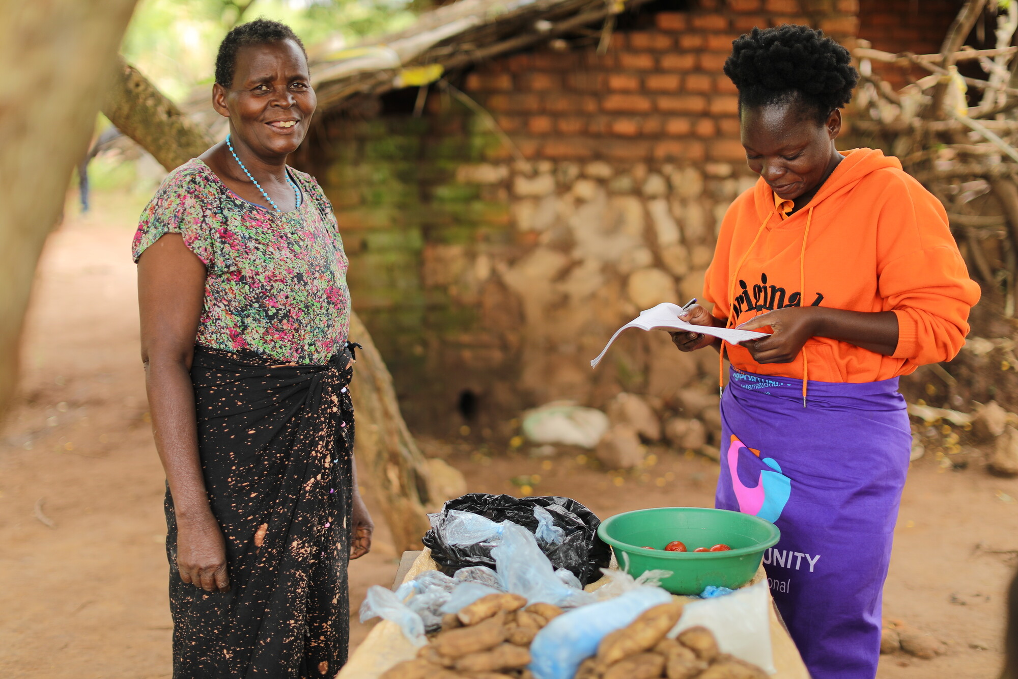Stella, left, receiving training from Opportunity International's case worker Alice